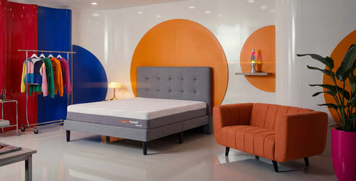 Modern bedroom with colorful walls, bed, and furniture.