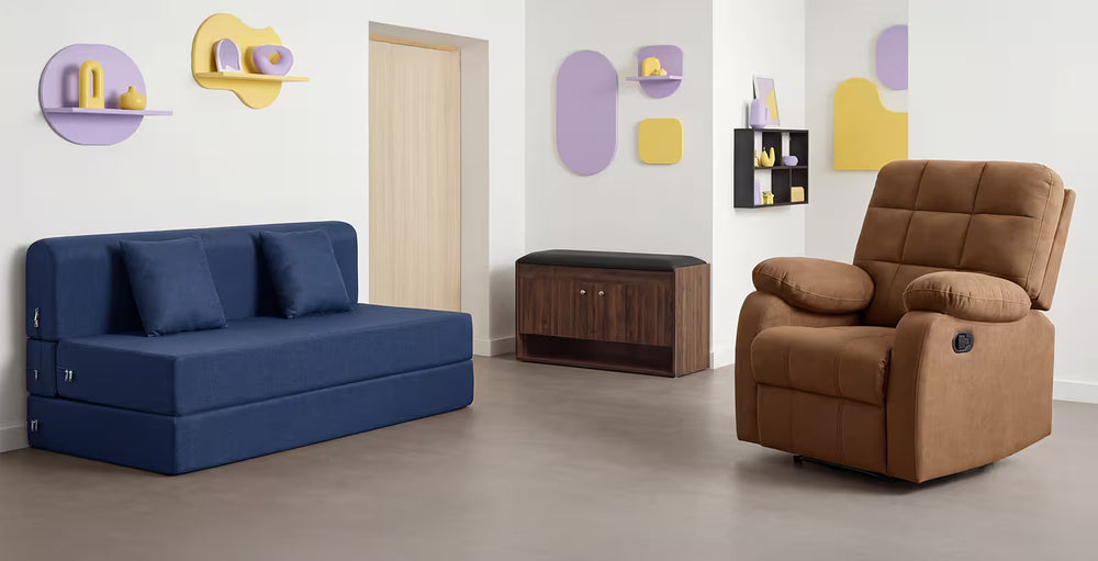 Blue sofa bed and brown recliner chair in a room with decorative wall shelves.